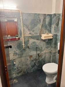 a bathroom with a toilet and a shower at Tranquil Tents in Trivandrum +1 photo