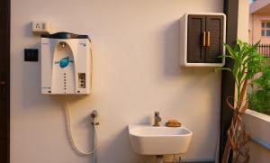 a bathroom with a sink and a hair dryer on the wall at Tranquil Tents in Trivandrum