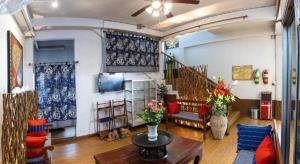 a living room with a couch and a table with flowers at Miami Hotel in Chiang Mai