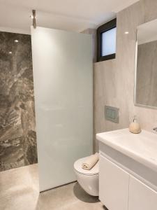 a bathroom with a white toilet and a sink at Soula Apartments & Studios in Palaiochora +89 photos