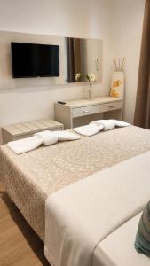 two beds in a room with a tv on the wall at Soula Apartments & Studios in Palaiochora