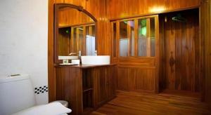 a bathroom with a wooden door and a toilet at Srisawat Resort in Cha Am +179 photos