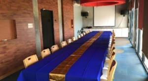 a long blue table and chairs in a room at Klim Hotel in Buriram +129 photos