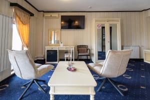 a living room with a table and two chairs at Hotel Ambasador Iasi in Valea Lupului