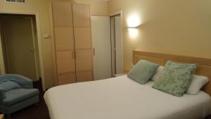 a bed with two pillows and a chair in a room at Residence Club Inn in Nice