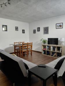 a living room with a couch and a table at De Cá - suite com acesso independente e kitchenette in Lousã