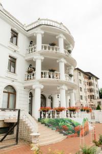 a large white building with stairs and flowers at Hotel Ambasador Iasi in Valea Lupului