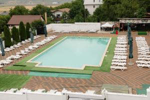 a large swimming pool with lounge chairs and umbrellas at Hotel Ambasador Iasi in Valea Lupului