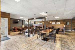 a restaurant with tables and chairs in a room at Days Inn by Wyndham Sylvan Lake in Sylvan Lake