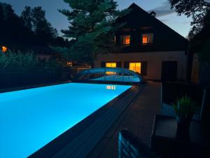 a swimming pool in front of a house at night at Chalupa Hnízdo Jetřichovice in Jetřichovice