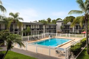 an image of the pool at a resort with palm trees at Ramada by Wyndham Cocoa in Cocoa