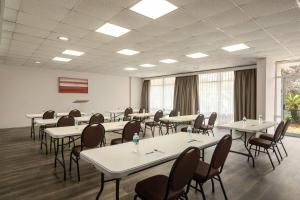 a large room with tables and chairs and windows at Ramada by Wyndham Cocoa in Cocoa
