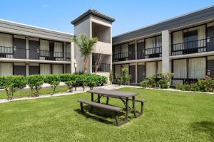 a picnic table in the grass in front of a building at Ramada by Wyndham Cocoa in Cocoa