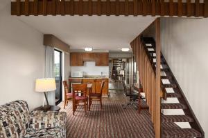 a living room with a staircase leading to a kitchen at Ramada by Wyndham Campbell River in Campbell River