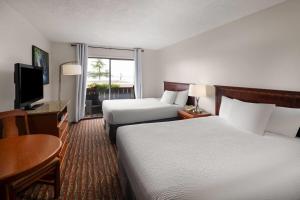 a hotel room with two beds and a flat screen tv at Ramada by Wyndham Campbell River in Campbell River +64 photos