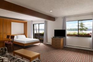 a hotel room with a bed and a television at Ramada by Wyndham Campbell River in Campbell River