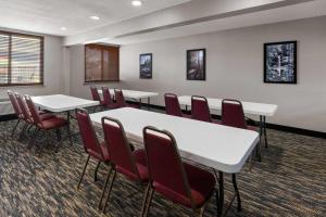 a conference room with white tables and red chairs at Americinn by Wyndham Appleton Downtown in Appleton +135 photos