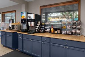 a coffee shop with blue cabinets and a counter at Americinn by Wyndham Appleton Downtown in Appleton
