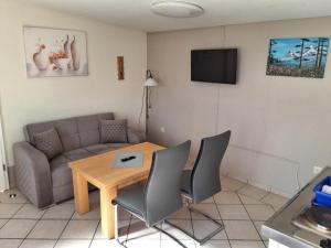 a living room with a couch and a table and chairs at NEU Ferienhaus am Saaler Bodden in Bartelshagen
