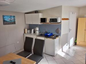 a small kitchen with a sink and a microwave at NEU Ferienhaus am Saaler Bodden in Bartelshagen