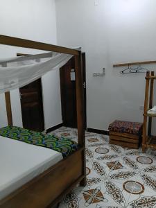 a bedroom with a bed and a tile floor at Casa twende A in Nungwi +19 photos