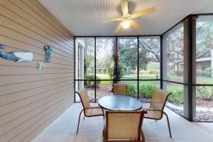 a screened porch with a ceiling fan and a table and chairs at Exclusive 3BR villa: pools near Disney magic in Kissimmee