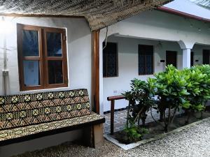 a bench sitting outside of a house with plants at Casa twende A in Nungwi