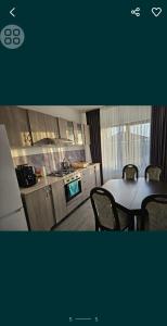 a kitchen with a table and chairs in a kitchen at Pensiunea LA ANI in Vadu