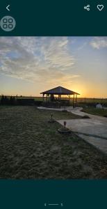 a gazebo in the middle of a field at Pensiunea LA ANI in Vadu