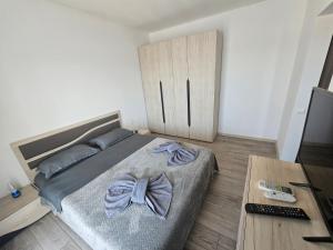 a bedroom with a bed with a bow on it at Pensiunea LA ANI in Vadu