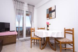 トロギールにあるApartmani Cubelaのテーブルと椅子とテレビのあるダイニングルーム