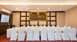 a meeting room with a large table and white chairs at Phuglong Hotel in Phayao