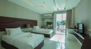 a hotel room with two beds and a television at Phuglong Hotel in Phayao +77 photos