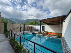 a swimming pool on the side of a house at Qafqaz Suite Wood Stack in Gabala