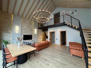 a living room with a couch and a table and a chandelier at Qafqaz Suite Wood Stack in Gabala