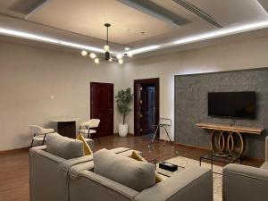 a living room with two couches and a flat screen tv at شير فل الرس in Ar Rass