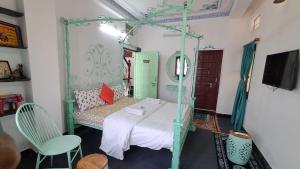 a bedroom with a canopy bed with a white bedspread at Raahi Backpacker's Hostel- Lake View in Udaipur