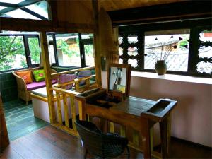 a room with a table and chairs and windows at Lijiang Baisha Free Time Designed Hotel in Lijiang