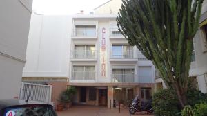 un grande edificio bianco con una palma di fronte di Residence Club Inn a Nizza