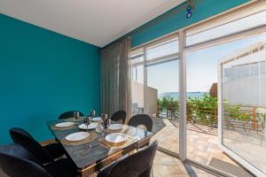 a dining room with a table and chairs and a large window at Великі котеджі з терасами у моря Совіньйон in Odesa