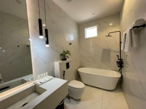 a bathroom with a tub and a toilet and a sink at شير فل الرس in Ar Rass