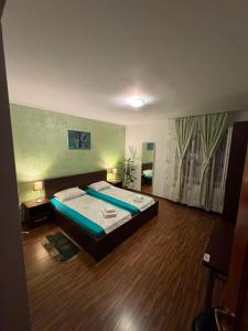 a bedroom with a bed and a wooden floor at Casa Sidor in Baile Felix