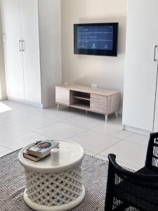 a living room with a tv and a coffee table at Modern Heritage Condo in Fourways