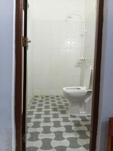 a bathroom with a toilet and a tiled floor at Casa twende A in Nungwi