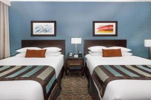 2 letti in una camera d'albergo con pareti blu di Wingate by Wyndham Sylvania-Toledo a Sylvania