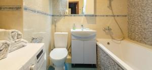 a bathroom with a toilet and a sink and a tub at Apart with Panorama View Позняки Харьковская in Kyiv