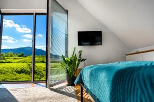 a bedroom with a bed and a large window at Beskid Island in Dobra