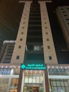 a tall building with a sign in front of it at فندق بياب العزيزية - Beyab Azizia Hotel in Mecca