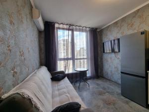 a living room with a couch and a refrigerator at Апартаменти з Панорамним Краєвидом на Озеро in Kyiv
