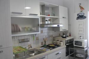eine kleine Küche mit einer Spüle und einer Mikrowelle in der Unterkunft La Casa Di Nina in Matera